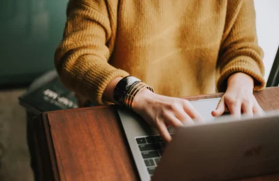 A woman typing on a laptop, representing the online counselling and therapy services offered by Lynn Guthrie.