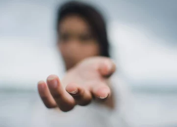 A symbolic image of a person standing in a hand, representing support, guidance, and empowerment offered by Lynn Guthrie at The Empathic Therapist.