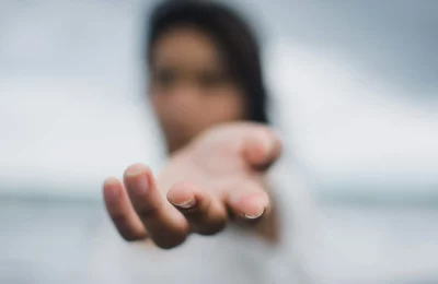 A symbolic image of a person standing in a hand, representing support, guidance, and empowerment offered by Lynn Guthrie at The Empathic Therapist.